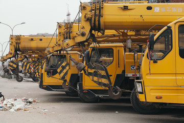 14,Dec,2014 - Beijing China,Yellow Crane trucks,on the road beside rubbish