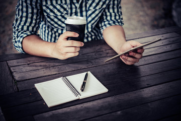 Young man using digital tablet while drinking Coffee sitting at home garden, Relaxing in the morning.