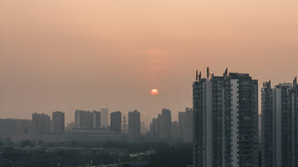 Fototapeta na wymiar sunset in foggy beijing