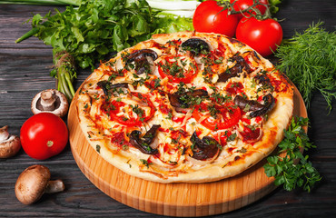 Fresh tasty pizza on black background on rustic wooden table with ingredients. Italian food.