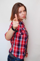 Girl hipster in the red plaid shirt on white background gesture right at you, the choice is yours. Portrait of woman pointing with his finger. Young successful businesswoman pointing at you.