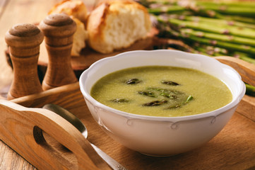Asparagus cream soup on wooden tray.
