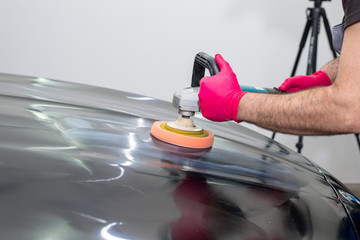 A man polishes a black car