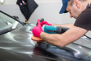 A man polishes a black car