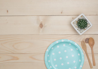 Top view empty color dish, fork and spoon on wooden table.Color dish has pattern  dot.