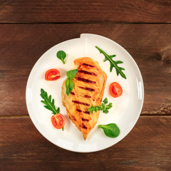 Grilled chicken fillet with cherry tomatoes and salad leaves