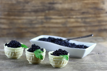 Fototapeta na wymiar black caviar on a wooden background