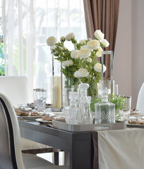 dining wooden table and comfortable chairs in modern home with elegant table setting