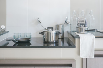 Fototapeta na wymiar Stainless steel kitchenware on black top counter