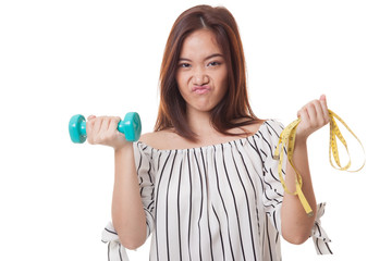 Exhausted  Asian woman with dumbbells and measuring tape.