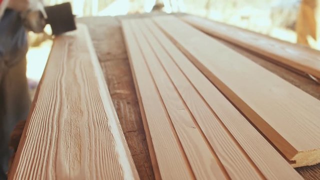 The working joiner processes boards. Wire brush during machining wood. Brushing wood work.