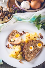 Vintage photo of portion of meatloaf on white plate with mashed potatoes and eggs