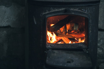 Fire burning in black iron stove. Closeup