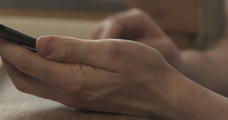 young man hands using smartphone sitting at the table closeup, 4k photo