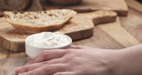 taking ricotta cheese to spread on bread, 4k photo