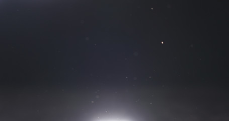 dust particles fast moving over black background from below, 4k photo