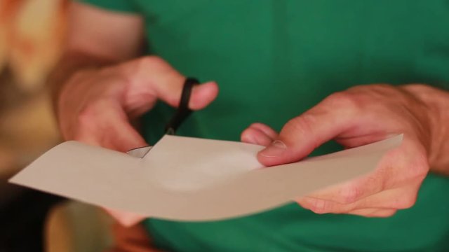 Man cutting paper with scissors
