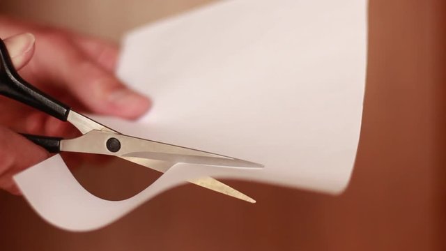 Cutting white paper with scissors