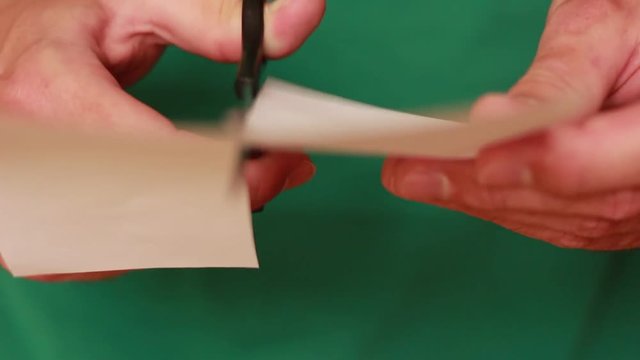 Cutting paper with scissors closeup
