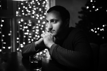 man holding glass of alcohol with ice in a night club 