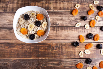 A plate with oats and dry fruits on wooden table