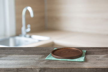Blurred and abstract background. Empty wooden tabletop with tray and defocused modern kitchen background for display or montage your products.