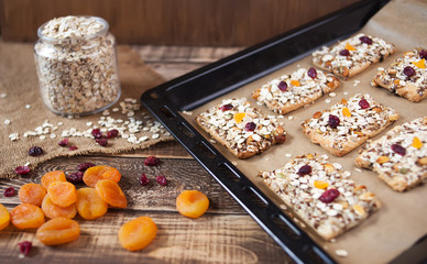 Baked oats with dry fruits, a jar with oats on wooden table