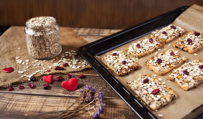 Baked oats with dry fruits, a jar with oats on wooden table