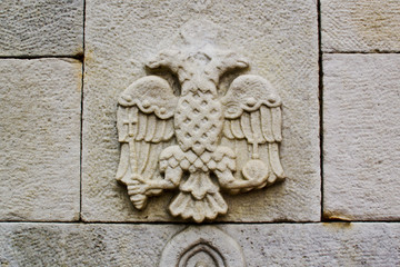 double-headed eagle, emblem of the Russian Federation on the stone wall of an old, ancient building of Ancient Russia