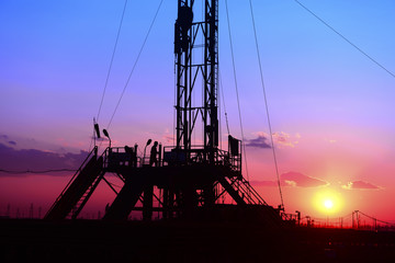 The oil derrick, under the background of the setting sun