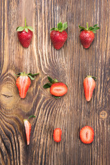 half red strawberries beautifully put on burnt plank