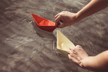 Paper boats in female hands