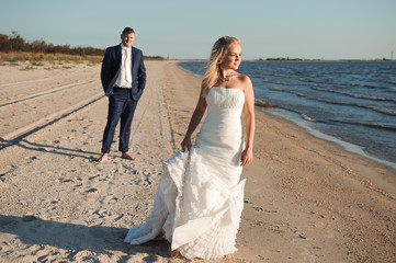 Fototapeta na wymiar Bride and groom by the sea on their wedding day