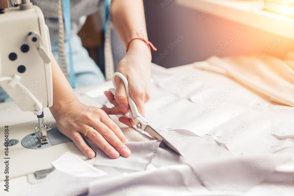 Wall mural pattern, scissors, tape measure, and a sewing machine. workplace of seamstress. dressmaker cuts dres