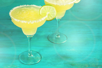 Lemon Margarita cocktails on vibrant teal with copyspace