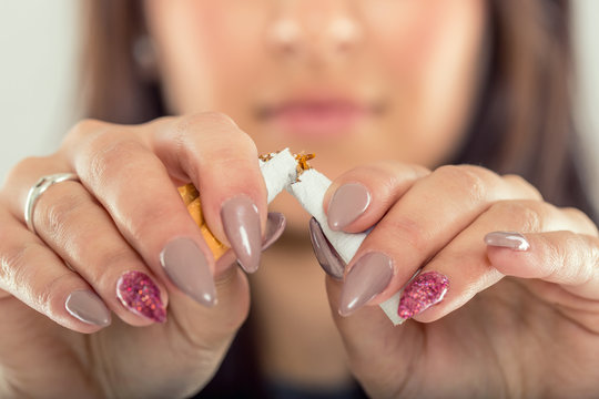Quit smoking.Woman hands breaking bunch of cigarette.
