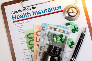 Application form for health insurance, paperwork, questionnaire, pen, tablet, calculator, money and stethoscope. Calculate for health insurance concept.