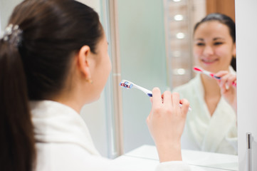 Portrait of young beautiful woman brushing her teeth with toothbrush