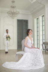 Chic wedding couple groom and bride posing in a white Studio. Happy couple laughing. White dress....