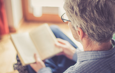 Älterer Herr liest in einem Buch, Seitenaufnahme