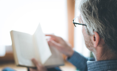 Älterer Herr liest in einem Buch, Seitenaufnahme, Breitbild
