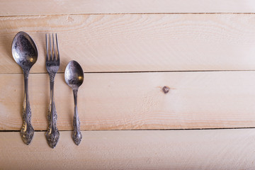 Fork, spoon, knife on the wooden table background with copy place. Concept kitchen and restaurant...