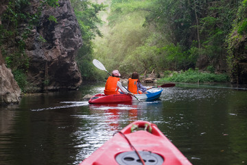 Summer vacation - Back view of traveller kayaking on river