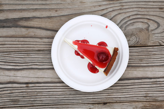 Slice Of Cheesecake Topped With Cherry Compote On Plate On Brown Table With Dessert, Top View