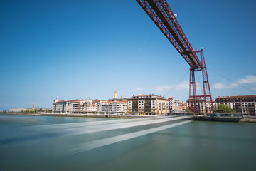 Obraz premium Daylight long exposure of Vizcaya hanging bridge and Nervion river in Portugalete, Bilbao, Spain.
