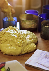Yeast dough on a table in the background of forms for baking
