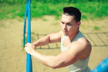 Obraz premium Sport, street workout concept - sportsman near the horizontal bar outdoors.