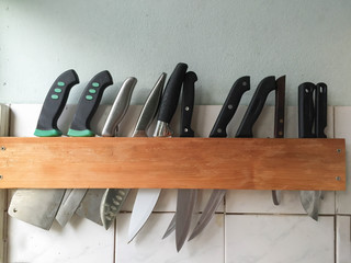 Many large knife hanging wooden storage knife in the kitchen