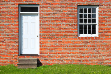 Door and single window on brick wall