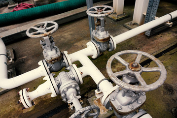 Old and rusted valves and pipeline at a jetty
